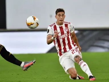 Bek Olympiakos, Kostas Tsimikas (kanan) mengumpan bola saat bertanding melawan Wolves pada leg kedua babak 16 besar Liga Europa di Molineux Stadium, Wolverhampton, Inggris, (6/8/2020). Tsimikas resmi direkrut Liverpool dengan biaya mencapai 11,7 juta pound sterling. (AP Photo/Rui Vieira)