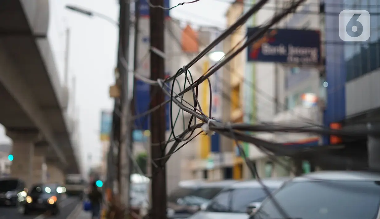 Instalasi kabel menjuntai di Jalan Panglima Polim, Kebayoran Baru, Jakarta, Kamis (31/10/2019). Buruknya pemasangan instalasi kabel di Ibukota menyebabkan banyak kabel yang menjuntai hingga mengganggu ketertiban umum. (Liputan6.com/Immanuel Antonius)