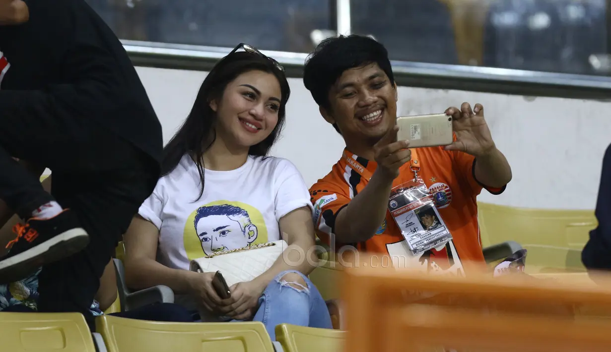 Ariel Tatum tetap tersenyum melayani sesi foto bersama fans di tribun VIP menyaksikan laga Persija Jakarta melawan Sriwijaya FC di Stadion Wibawa Mukti, Cikarang, Jumat (16/6/2017). (Bola.com/Nicklas Hanoatubun)