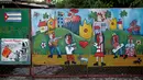 Lukisan bergambar bendera Kuba dan sejumlah orang di desa Jaimanitas, Havana, Kuba, (14/7). Fuster telah mengubah desanya menjadi lebih indah dengan warna-warni lukisan dan mosaik. (REUTERS / Enrique de la Osa)