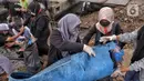 Sukarelawan Kelas Jurnalis Cilik saat membersihkan sampah di kawasan Cilincing, Jakarta Utara, Minggu (5/12/2021). Kegiatana ini guna mengurangi sampah yang berdatangan akibat banjir rob. (merdeka.com/Iqbal S. Nugroho)