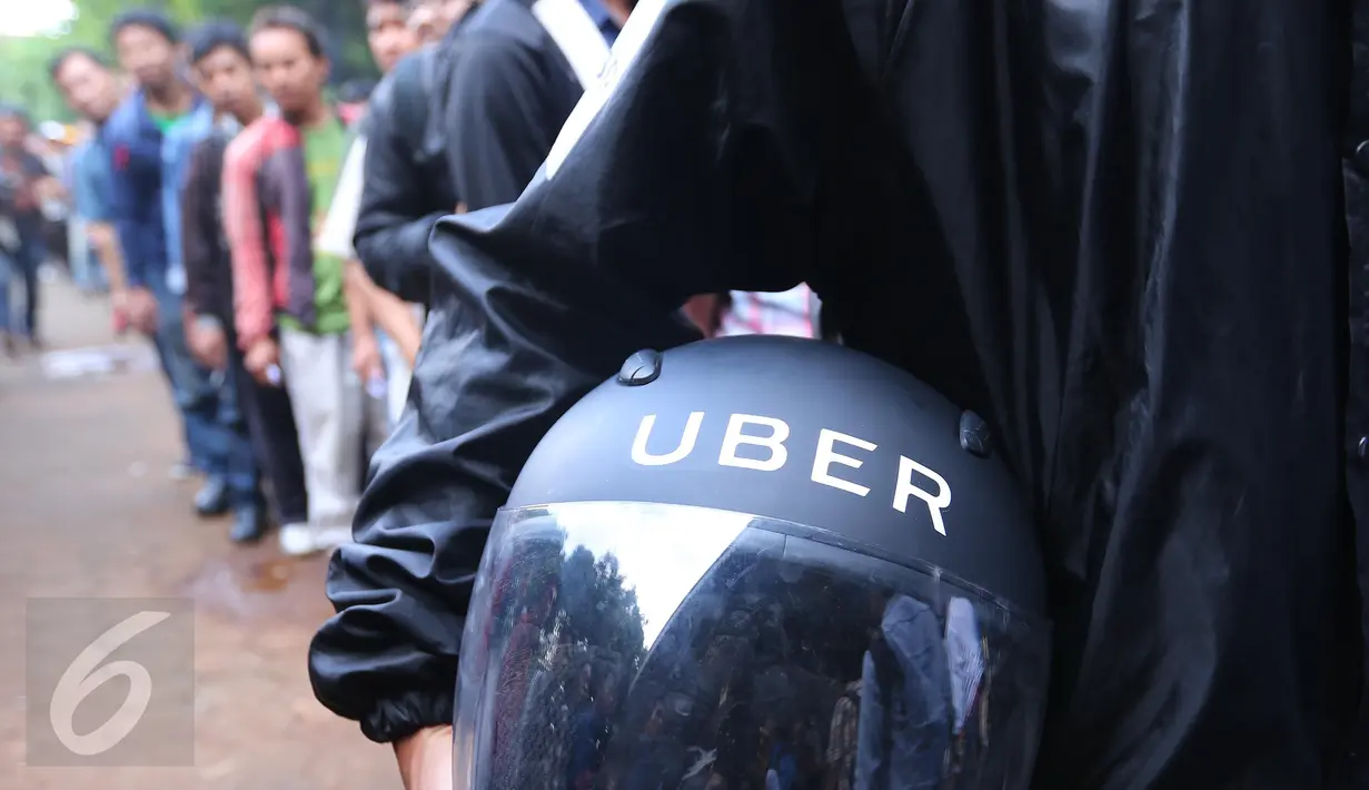 Seorang warga memegang helm Uber usai melakukan pendaftaran menjadi pengemudi Uber di Jakarta, Selasa (24/5). Antusias warga untuk mendaftat ojek Online masih sangat besar bila dilihat dari jumlah pendaftar. (Liputan6.com/Angga Yuniar)