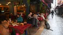 Pelanggan makan di sebuah restoran di Besiktas, Istanbul, setelah negera tersebut melonggarkan pembatasan, Selasa (2/3/2021). Pemerintah Turki menutup semua restoran untuk makan di tempat pada November dan memberlakukan penguncian wilayah pada akhir pekan secara nasional. (Ozan KOSE/AFP)