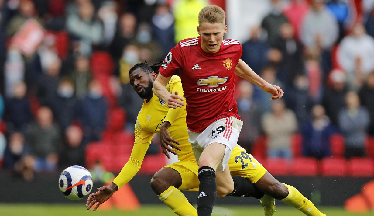 Gelandang Manchester United, Scott McTominay (depan) berusaha ditekel gelandang Fulham, Andre-Frank Zambo Anguissa dalam laga lanjutan Liga Inggris 2020/2021 pekan ke-37 di Old Trafford Stadium, Rabu (18/5/2021). Manchester United bermain imbang 1-1 dengan Fulham. (AFP/Phil Noble/Pool)