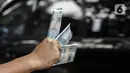 Penjual jasa penukaran uang menawarkan uang baru pecahan Rp 2.000 di kawasan Pondok Indah, Jakarta, Kamis (6/5/2021). Penjual jasa musiman tersebut mulai ramai menjelang Lebaran. (Liputan6.com/Johan Tallo)