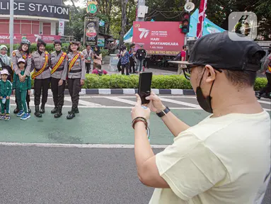 Sejumlah anak berfoto dengan polisi wanita (Polwan) saat Car Free Day (CFD) di Bundaran HI, Jakarta, Minggu (2/7/2023). Masih dalam nuansa memperingati HUT ke-77 Bhayangkara, kehadiran Polwan saat CFD menyita perhatian warga untuk berswafoto. (Liputan6.com/Faizal Fanani)