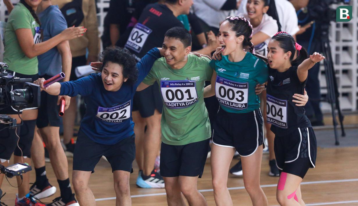Selebritas Indonesia, Cinta Laura (kedua kanan) melakukan selebrasi bersama timnya (kiri ke kanan) Bastian Steel, Raditya Dika, dan Aqeela Calista setelah memenangkan lomba lari estafet 400 meter nomor campuran Turnamen Olahraga Selebriti Indonesia (TOSI) di GOR UNJ, Rawamangun, Jakarta, Minggu (30/07/2023). Mereka berhasil finis dengan catatan waktu 1 menit 0,59 detik. (Bola.com/Bagaskara Lazuardi)