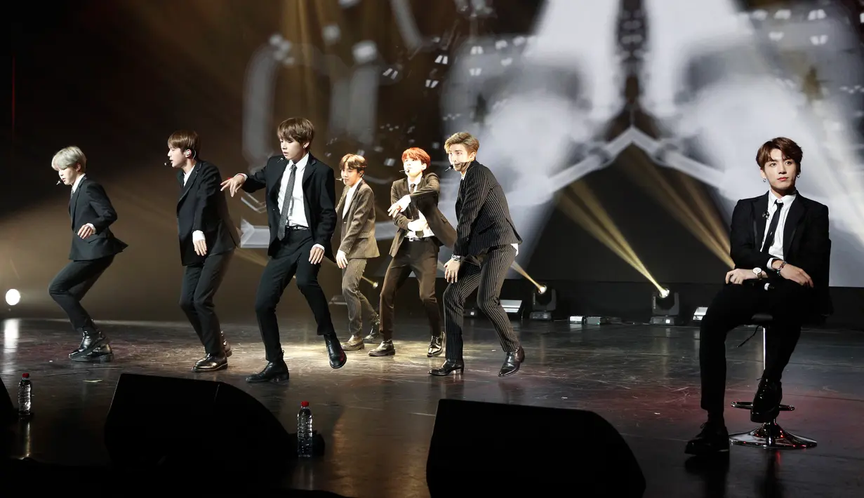 Penampilan boyband K-pop, BTS dalam konser negara persahabatan antara Korea Selatan dan Prancis yang digelar di Paris, Minggu (14/10). Pada penampilan tersebut personel BTS, Jungkook, masih duduk di kursi karena cedera kaki. (YOAN VALAT/POOL/AFP)
