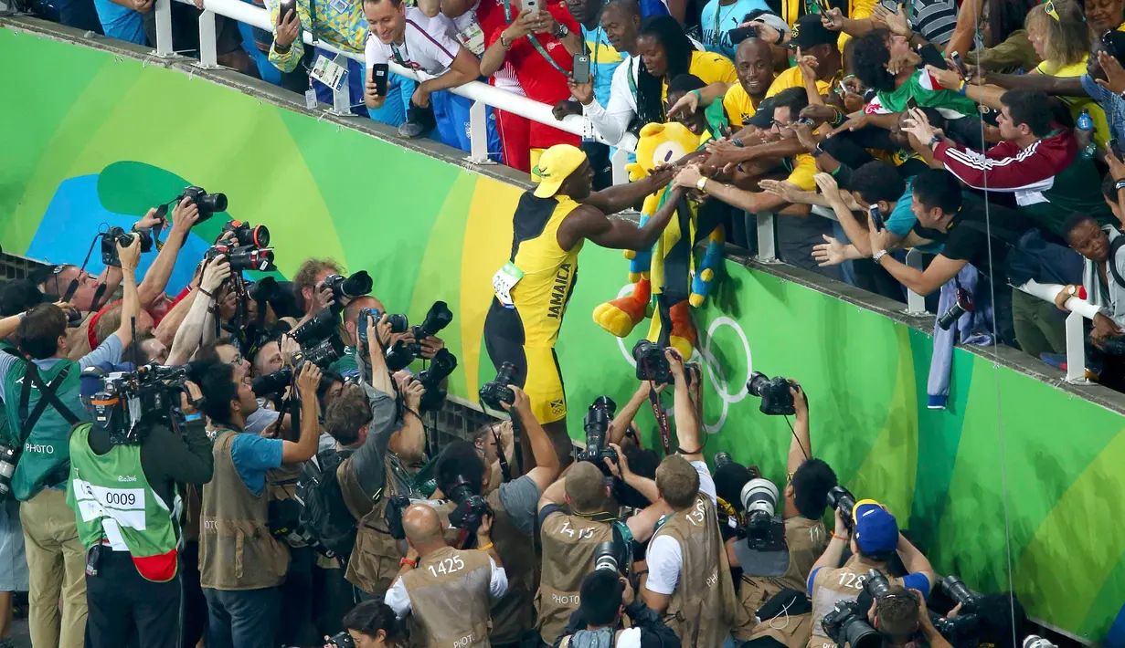 Usain Bolt melakukan selebrasi bersama penggemarnya usai meraih emas kategori sprint 100 meter Olimpiade 2016 di Rio de Janeiro, Brasil, (15/8). Bolt finish dengan catatan waktu 9,81 detik. (REUTERS/Carlos Barria)     