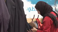 Wanita Lebanon menggantung pakaiannya di Wall Of Kindness, Beirut, Lebanon (UNCHR)