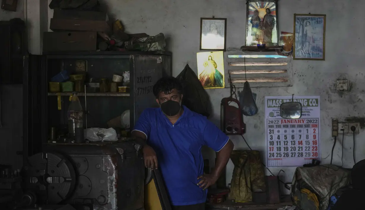 Seorang pemilik bengkel menghentikan pekerjaannya dan menunggu selama pemadaman listrik di Wattala, Kolombo, 23 Februari 2022. Sri Lanka menerapkan pemadaman listrik bergilir akibat krisis keuangan yang memicu kekurangan bahan bakar dan melumpuhkan jaringan listriknya. (AP Photo/Eranga Jayawardena)