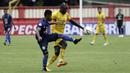 Striker Bhayangkara FC, Herman Dzumafo, berebut bola dengan pemain Arema FC pada laga Shopee Liga 1 di Stadion PTIK, Jakarta, Rabu (27/11). Bhayangkara menang 1-0 atas Arema. (Bola.com/Yoppy Renato)