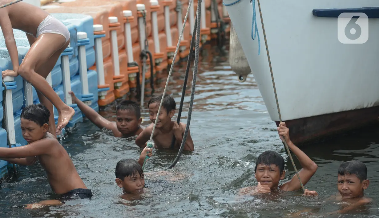 Anak-anak bermain di kawasan Muara Angke, Jakarta, Sabtu (10/4/2021). Minimnya lapangan dan taman-taman hingga kondisi laut yang terlalu kotor merupakan bentuk tak terpenuhinya hak-hak dasar anak-anak nelayan di Jakarta. (merdeka.com/Imam Buhori)