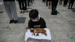 Para aktivis dari kelompok 'Animal Liberation Wave' dan 'Last Chance for Animals' membawa anak anjing mati yang diambil dari peternakan daging anjing di Gwanghwamun Plaza, Seoul (7/7). Mereka memprotes perdagangan daging anjing. (AFP Photo/Ed Jones)