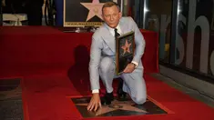 Daniel Craig berpose di atas bintang barunya di Hollywood Walk of Fame pada upacara penghargaan di Los Angeles, Rabu (6/10/2021). Nama Daniel Craig di Hollywood Walk of Fame diletakkan di samping aktor Roger Moore, pemeran James Bond terdahulu. (AP Photo/Chris Pizzello)