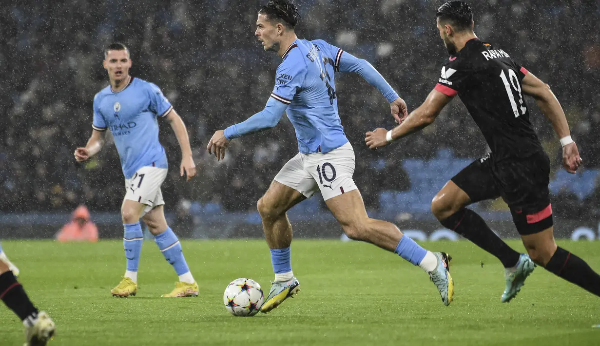 Gelandang Manchester City, Jack Grealish membawa bola dari kawalan pemain Sevilla, Rafa Mir, selama pertandingan grup G Liga Champions di stadion Etihad di Manchester, Inggris, Kamis (3/11/2022). Kemenangan ini memantapkan posisi Man City sebagai juara Grup G dengan mengoleksi 14 poin. (AP Photo/Rui Vieira)