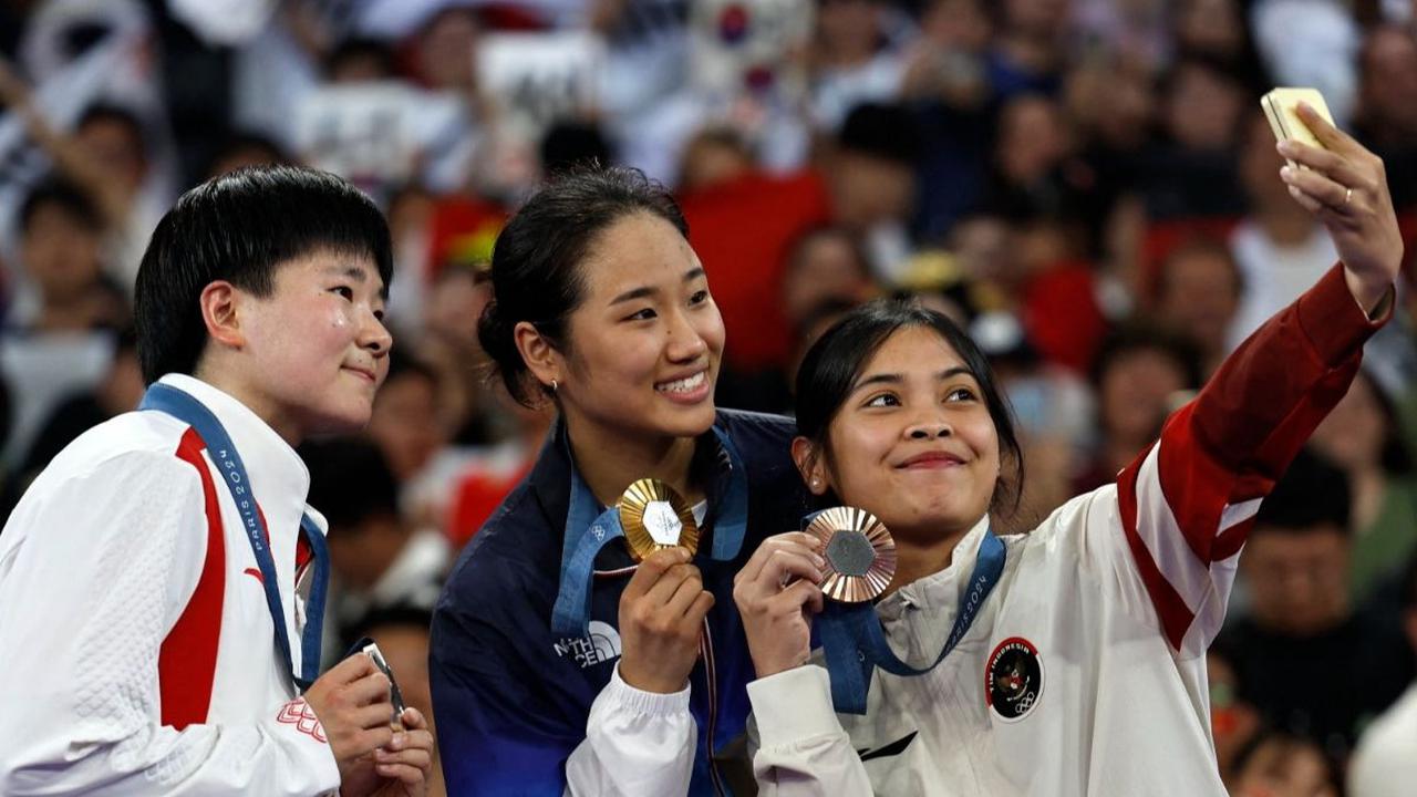 Pebulutangkis tunggal putri Indonesia, Gregoria Mariska tersenyum sembari memamerkan medali perunggu Olimpiade Paris 2024 saat berfoto bersama An Se Young asal Korea Selatan dan He Bing Jo asal China di Porte de La Chapelle Arena, Paris, Prancis, Senin (