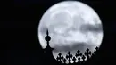 Bulan purnama terbit di atas kastil Schwerin, di Schwerin, Jerman, Selasa, 1 Agustus 2023. Setelah Sturgeon Moon, bulan purnama berikutnya adalah Blue Moon yang jatuh pada 30 Agustus 2023. (Jens Büttner/dpa via AP)