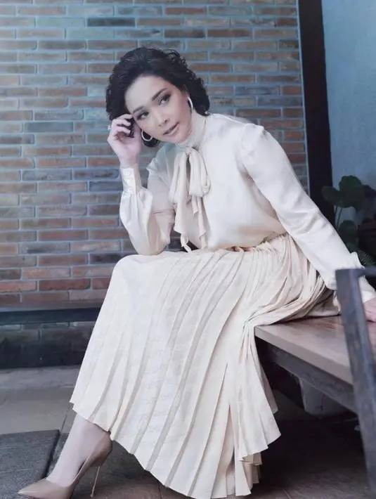 Bak lady boss, Maia Estianty tampil kece dengan tie neck blouse dan rok plisket warna putih gading. @maiaestiantyreal.
