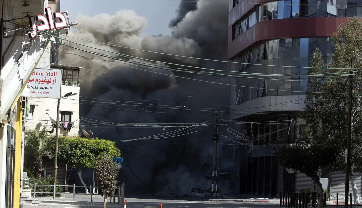 Serangan udara Israel menghantam gedung bertingkat tinggi yang menampung kantor The Associated Press di Kota Gaza, Sabtu (15/5/2021). Serangan terjadi satu jam usai militer Israel memerintahkan orang-orang untuk mengungsi dari gedung. (AP Photo/Khalil Hamra)