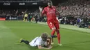 Pemain Valencia, Daniel Wass, terjatuh saat berebut bola dengan striker Real Madrid, Karim Benzema, pada laga La Liga 2019 di Stadion Mestalla, Rabu (3/4). Valencia menang 2-1 atas Real Madrid. (AP/Alberto Saiz)