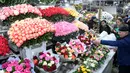 Pedagang bunga melayani pembeli jelang Hari Perempuan Internasional di pasar bunga di Moskow, Rusia (5/3). Hari Perempuan Internasional secara resmi dijadikan sebagai hari libur nasional di Soviet Rusia pada tahun 1917. (AFP Photo/Kirill Kudryavtsev)