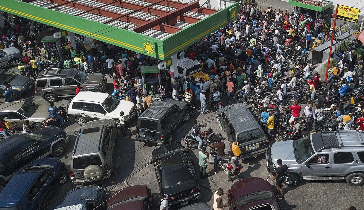 Pengemudi mobil dan motor menunggu dalam antrean panjang di salah satu dari beberapa SPBU terbuka selama kekurangan bahan bakar nasional di Port-au-Prince, Haiti, Minggu (31/10/2021). Situasi itu telah menambah beban penduduk yang masih berjuang menghadapi krisis ekonomi. (AP Photo/Matias Delacroix)