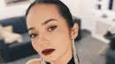 Enzy Storia tampil menawan dalam balutan dress dengan detail halter-neck, berwarna hitam. Rambut ditata sleek dipadu dengan pulasan lipstik merah. [Foto: Instagram/enzystoria]