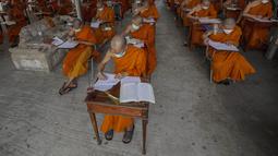 Sejumlah Biksu Buddha memakai masker untuk membantu melindungi diri dari virus corona, mengikuti tes bahasa Pali liturgi di Wat Molilokayaram di Bangkok, Thailand, Kamis (20/1/2022). (AP Photo/Sakchai Lalit)