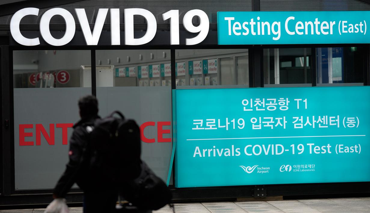 Seorang pelancong berjalan di luar pusat pengujian COVID-19 di Bandara Internasional Incheon, Incheon, Korea Selatan, Jumat (10/2/2023). Korea Selatan mengatakan akan menghapus pembatasan masuk yang diberlakukan pada pelancong jangka pendek dari China sejak awal tahun karena para pejabat melihat situasi COVID-19 di negara itu mulai stabil. (AP Photo/Lee Jin-man)