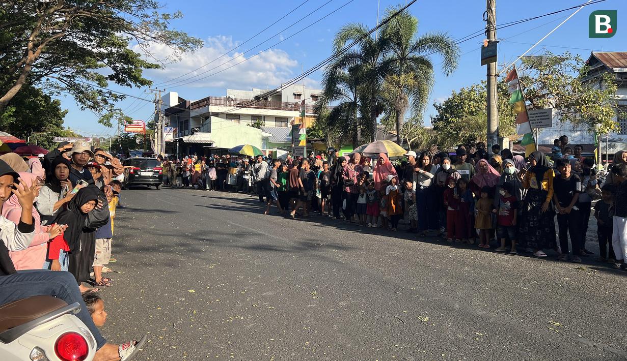 Masyakarat tumpa ruah di Jalan Yos Sudarso, Sumbawa, Jumat (23/6/2023) menanti parade pembalap MXGP Sumbawa 2023. (Bola.com/Wiwig Prayugi)