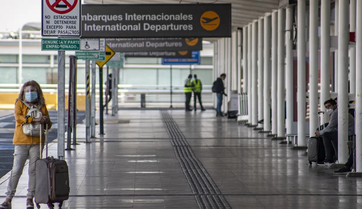 Seorang perempuan menunggu transportasi di luar bandara internasional Arturo Merino Benitez yang sepi pada hari pertama pemerintah menutup perbatasan di Santiago, Chile, Senin (5/4/2021). Kasus COVID-19 telah melonjak di Chile meskipun ada upaya vaksinasi. (AP Photo/Esteban Felix)