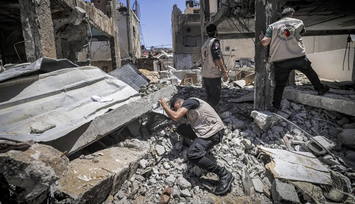 Pakar bahan peledak Hamas mencari proyektil yang tidak meledak dari reruntuhan bangunan setelah konflik Mei 2021 dengan Israel di Kota Gaza, Sabtu (5/6/2021). Perang 11 hari antara Hamas dan Israel menewaskan 254 orang Palestina dan 12 orang Israel. (MAHMUD HAMS/AFP)