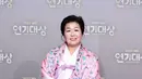 Byun Joong Hee tampil cantik mengenakan hanbok berwarna putih, dengan pita ungu muda. Penampilannya ini dibalut syal bercorak floral bernuansa pink. [Foto: Instagram/sbsdrama.official]