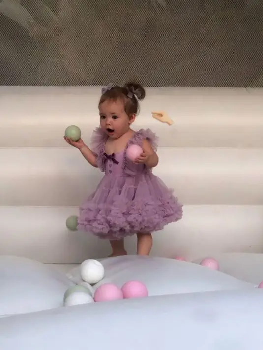 Sementara sang bintang utama dalam pesta ini, Kamari tampil menggemaskan dengan mini dress ungu dan tatanan rambut kuncir pigtails yang dihiasi pita warna senada.