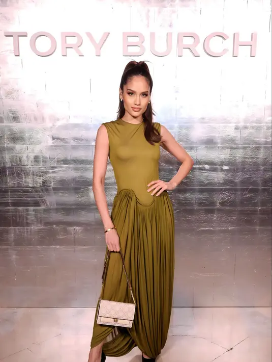 Cinta Laura tampil mengenakan Tory Burch Resort Look 23, dress sleeveless polos warna hijau. Dipadukan Broken Heel Pump. [Tory Burch]