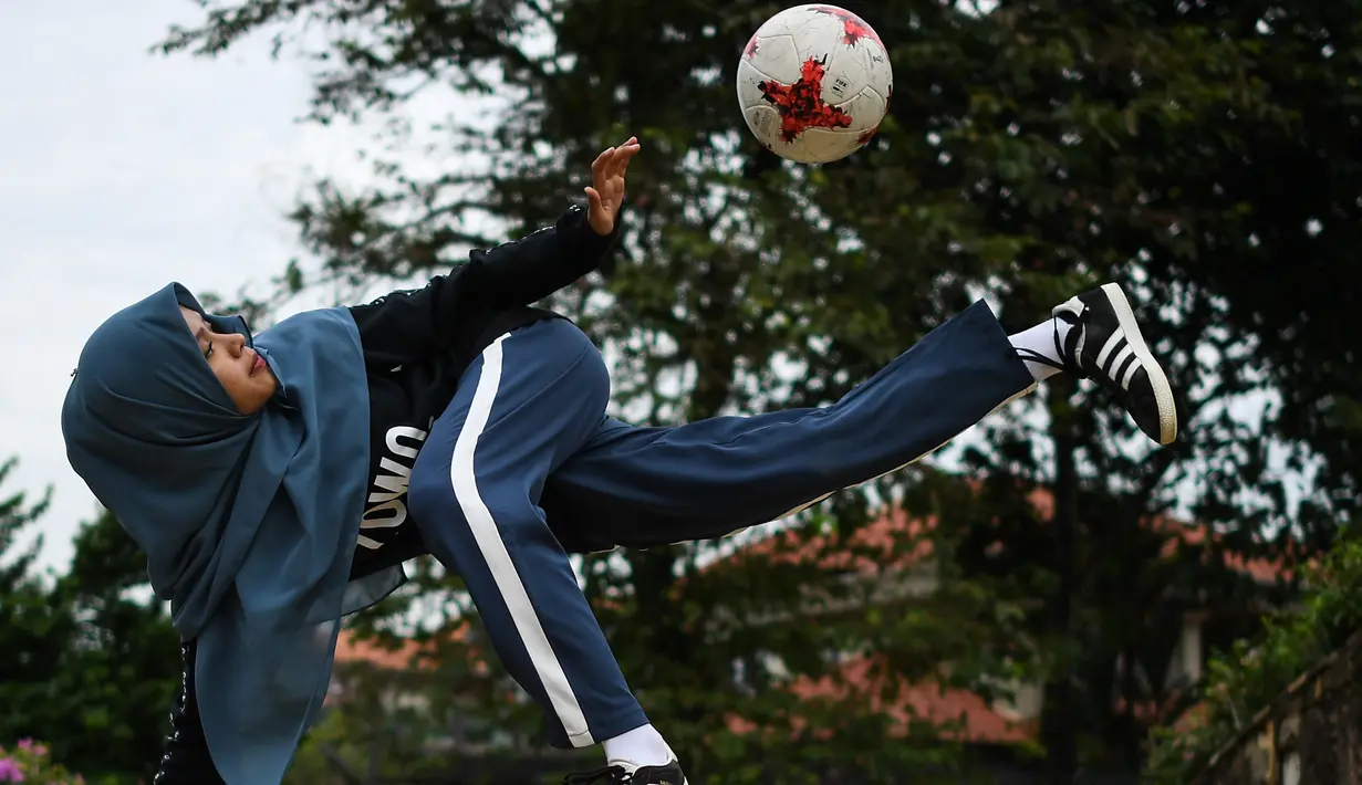 Freestyler sepak bola, Qhouirunnisa Endang Wahyudi saat menunjukkan keterampilannya men-juggling bola di sebuah taman di Klang, Kuala Lumpur, (11/7). (AFP Photo/Mohd Rasfan)
