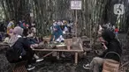 Wisatawan menyantap makanan saat berkunjung ke Pasar Papringan, Ngadiprono, Kabupaten Temanggung, Jawa Tengah, Minggu (26/2/2023). Pasar Papringan Ngadiprono menjadi salah satu destinasi wisata unik di Kabupaten Temanggung. (merdeka.com/Iqbal S. Nugroho)