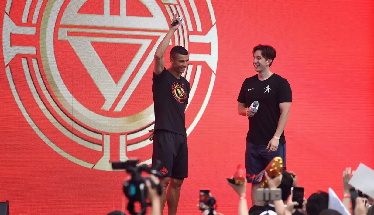 Pemain timnas Portugal, Cristiano Ronaldo menemui para penggemarnya dalam rangkaian “CR7 Tour” di Beijing, China, Kamis (19/7). Teriakan fans dan kilatan lampu kamera menyambut kedatangan bapak 4 orang anak tersebut. (WANG ZHAO/AFP)