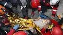 Petugas penyelamat berhasil mengevakuasi Ayda Gezgin, 3, yang terjebak reruntuhan gedung apartemen setelah gempa bumi dahsyat di kota Izmir, Turki, Selasa (3/11/2020). Ayda Gazgin berhasil diselamatkan dari bawah reruntuhan bangunan setelah terkubur selama 4 hari atau sekitar 91 jam. (AFAD via AP)