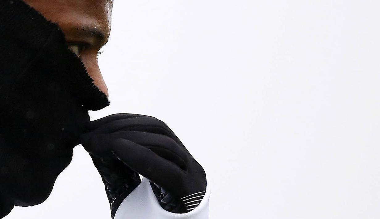 Bek Juventus, Patrice Evra, menutupi hidungnya karena dingin saat latihan jelang laga Liga Champions melawan Sevilla di Vinovo, Italia, Senin (21/11/2016). Cuaca dingin mewarnai latihan Juventus. (AFP/Marco Bertorello)