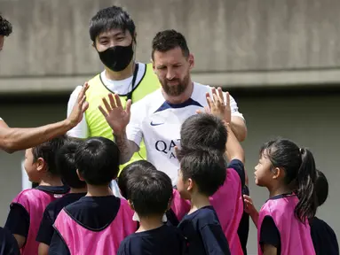 Pemain Paris Saint-Germain (PSG), Lionel Messi dan Marquinhos menyapa pesepak bola cilik saat memberikan pelatihan di Jepang. (AP/Eugene Hoshiko)