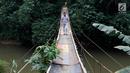 Jembatan yang berada di atas Sungai Ciliwung ini menjadi salah satu akses bagi warga untuk mempersingkat waktu menyeberang Lenteng Agung, Jakarta, Rabu (24/5). (Liputan6.com/Immanuel Antonius)