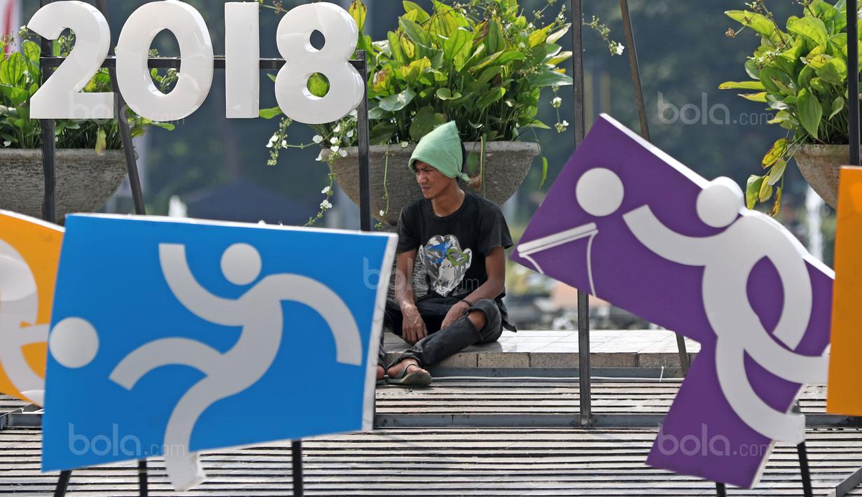 Pekerja beristirahat sejenak dekat logo cabang olahraga Asian Games 2018 di Bundaran HI, Jakarta, (17/8/2017), Asian Games mengambil tema Energy Of Asia dan akan dibuka oleh Presiden Republik Indonesia Joko Widodo. (Bola.com/Nicklas Hanoatubun)