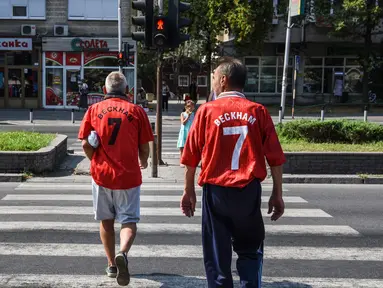 Dua pria mengenakan jersey legenda Manchester United David Beckham jelang pertandingan final UEFA Super Cup antara Real Madrid melawan MU di Philip II Arena di Skopje, Macedonia, (7 /8). (AFP Photo/Armend Nimani)