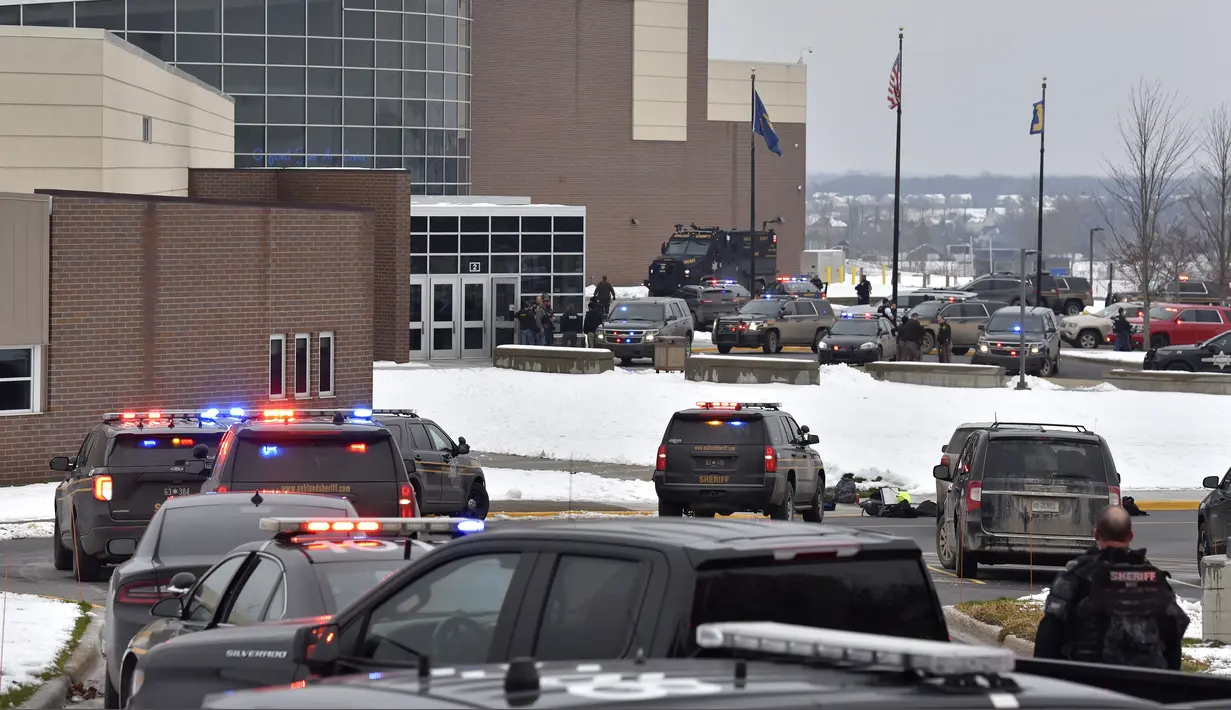 Puluhan personel polisi, pemadam kebakaran, dan EMS bekerja di lokasi penembakan di Oxford High School di Oxford, Michigan (30/11/2021). Tiga orang siswa tewas dan enam orang lainnya termasuk seorang guru terluka dalam peristiwa penembakan tersebut. (Todd McInturf/The Detroit News via AP)