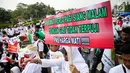 Massa membawa poster dalam aksi damai di depan Istana Negara, Jakarta, Rabu (19/7). Mereka mendesak revisi UU Aparatur Sipil Negara (ASN) yang berkeadilan agar para pegawai non PNS yang telah mengabdi bisa diangkat menjadi PNS (Liputan6.com/Faizal Fanani)