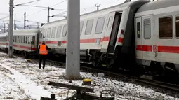Seorang petugas regu penyelamat berdiri di lokasi tabrakan yang melibatkan dua kereta penumpang dekat stasiun di Niklasdorf, Austria, Senin (12/2).  Sebanyak 19 ambulans dan 2 kendaraan darurat di kerahkan ke lokasi kejadian. (AP/Ronald Zak)