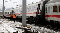Seorang petugas regu penyelamat berdiri di lokasi tabrakan yang melibatkan dua kereta penumpang dekat stasiun di Niklasdorf, Austria, Senin (12/2).  Sebanyak 19 ambulans dan 2 kendaraan darurat di kerahkan ke lokasi kejadian. (AP/Ronald Zak)