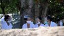 Umat Hindu mengenakan face shield menghadiri upacara Melasti menjelang Hari Raya Nyepi di Pantai Kuta, Bali (11/3/2021). Upacara Melasti dilakukan oleh perwakilan desa adat dengan jumlah terbatas serta menerapkan protokol kesehatan untuk mencegah penyebaran pandemi COVID-19. (AFP/Sonny Tumbelaka)